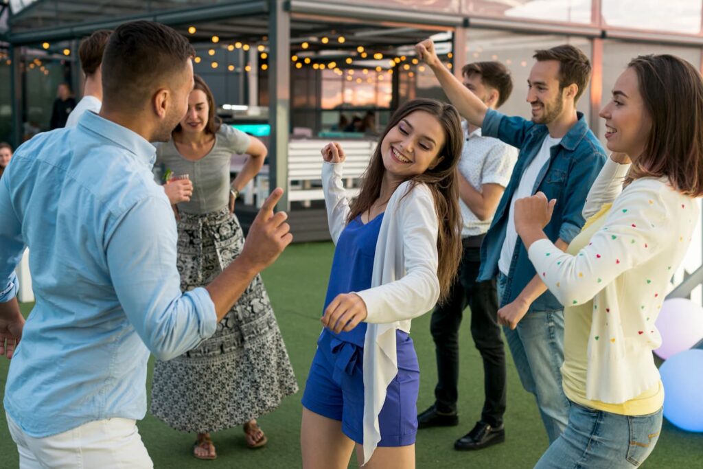 groupe de personnes qui danse au son de la musique en souriant